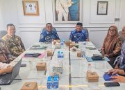 Bupati Tanah Laut duduk di depan peserta rapat TPID.