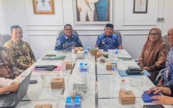 Bupati Tanah Laut duduk di depan peserta rapat TPID.