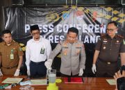 Petugas menuangkan bubuk dan butiran obat ke dalam blender, polisi lain melihat