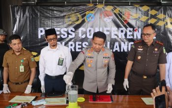 Petugas menuangkan bubuk dan butiran obat ke dalam blender, polisi lain melihat