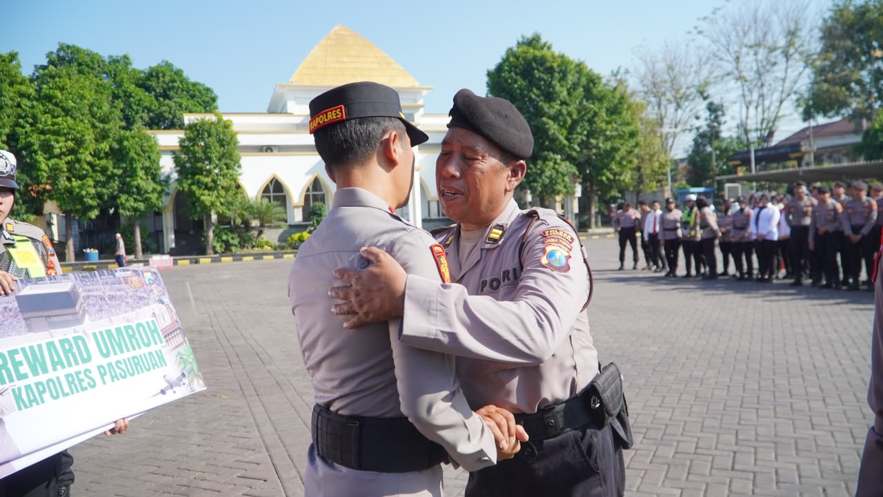 Kapolres merangkul anggota teladan penerima hadiah umrah.