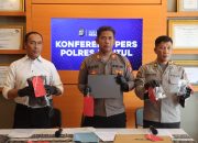 Polisi tunjukkan laptop dan uang di atas meja
