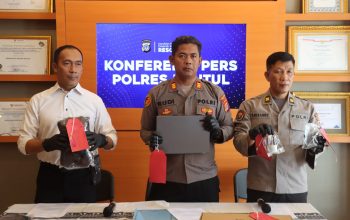 Polisi tunjukkan laptop dan uang di atas meja