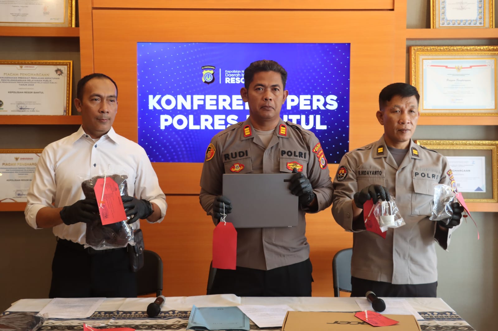 Polisi tunjukkan laptop dan uang di atas meja