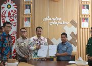 Bupati Pulang Pisau dan mitra tunjukkan dokumen MoU.