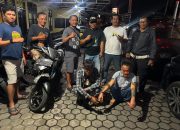 Dua motor terparkir di halaman kantor polisi, petugas berdiri di sampingnya