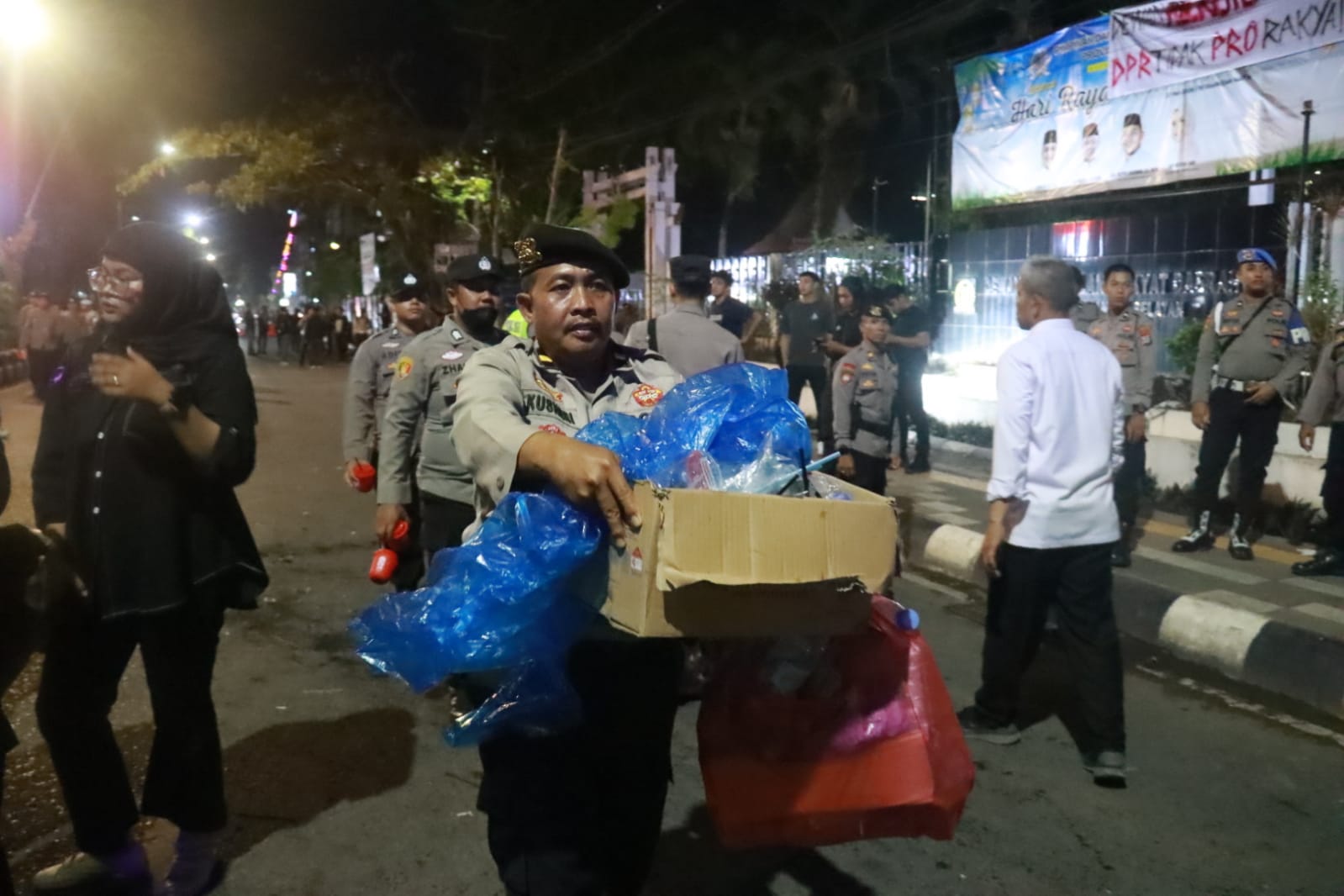 Polisi memungut sampah di halaman gedung