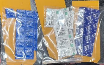 Polisi menunjukkan puluhan tablet obat di atas meja