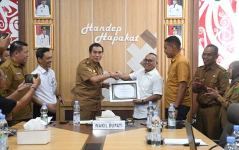 Empat orang berjabat tangan di depan piagam penghargaan