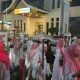 Kerumunan remaja membawa obor menyala berjalan di malam hari