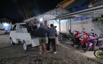 Polisi menaikkan motor ke bak mobil di pinggir jalan