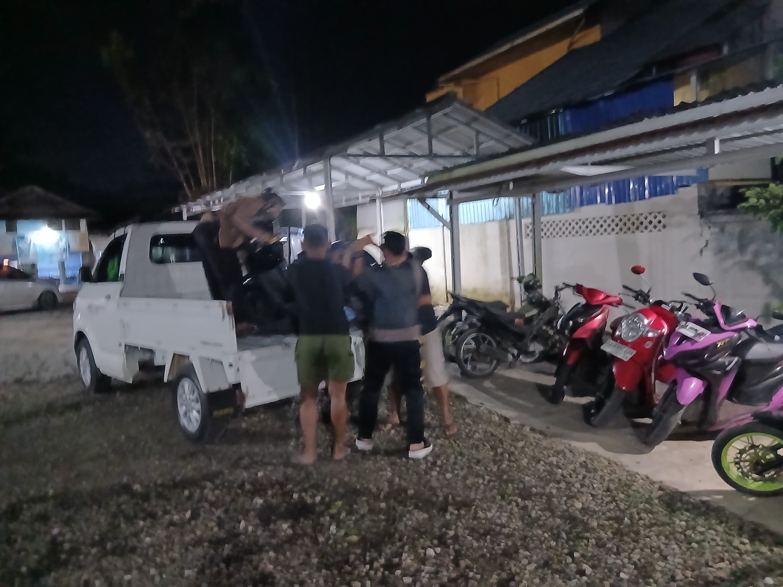 Polisi menaikkan motor ke bak mobil di pinggir jalan