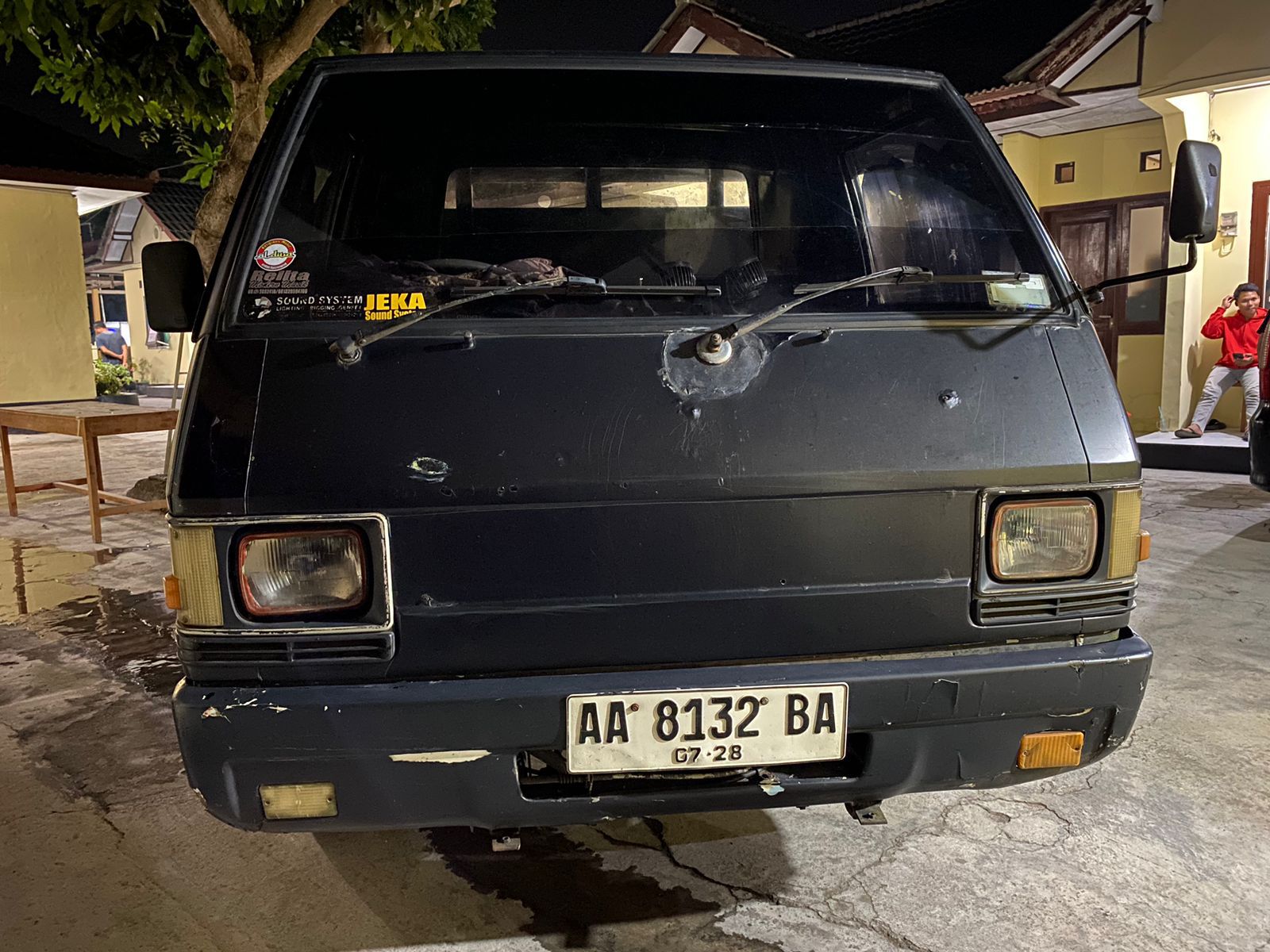 Mobil hitam dan ponsel di halaman kantor polisi