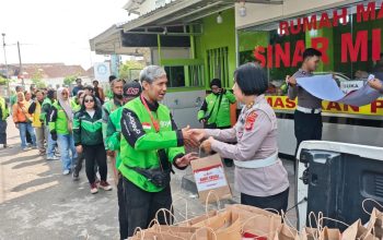 Polisi memberikan bingkisan ke pengendara ojol di pinggir jalan