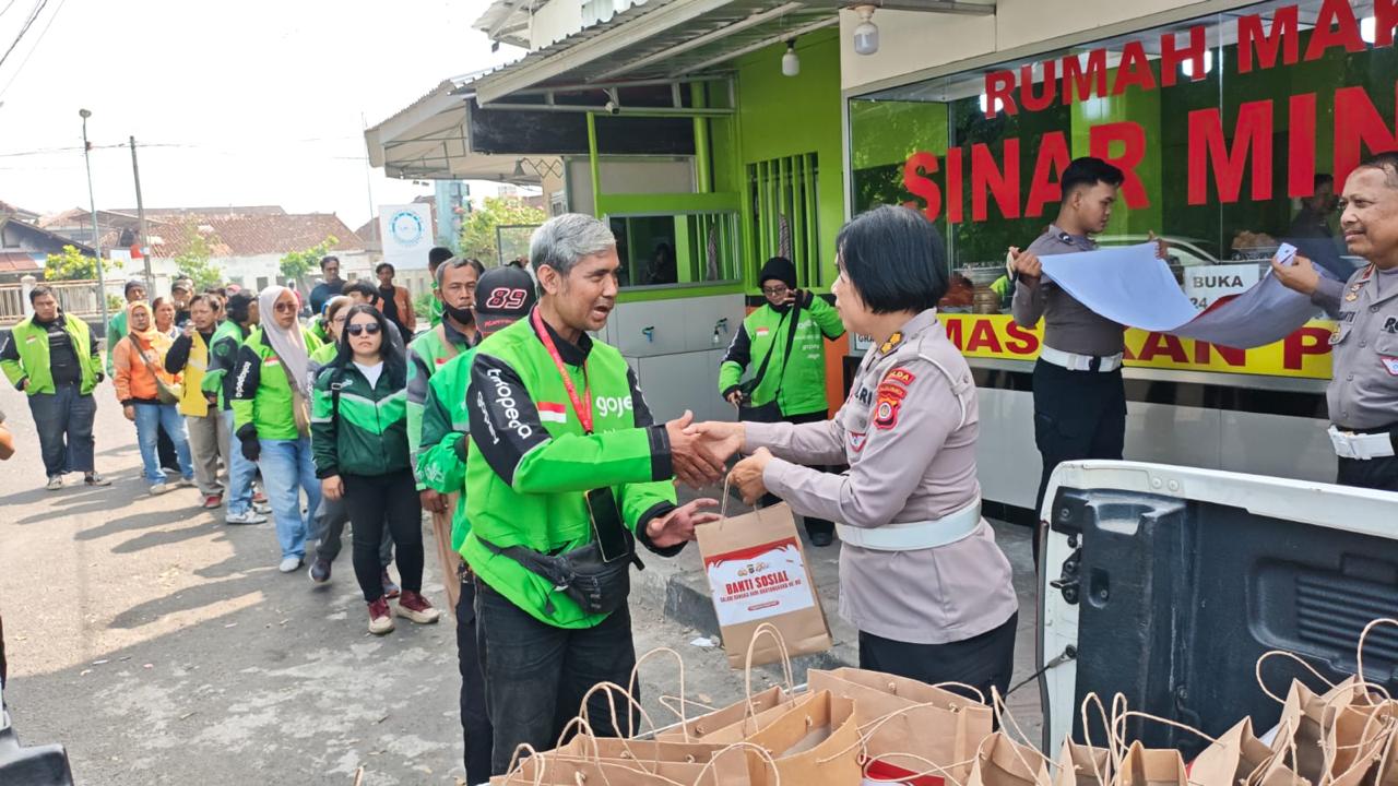 Polisi memberikan bingkisan ke pengendara ojol di pinggir jalan
