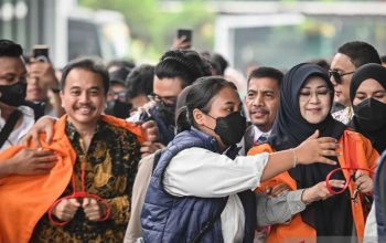 Dua orang pria dan wanita berjalan keluar dari gedung kejaksaan