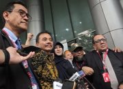 Dua orang pria dan wanita berjalan keluar dari gedung kejaksaan