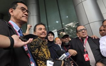Dua orang pria dan wanita berjalan keluar dari gedung kejaksaan