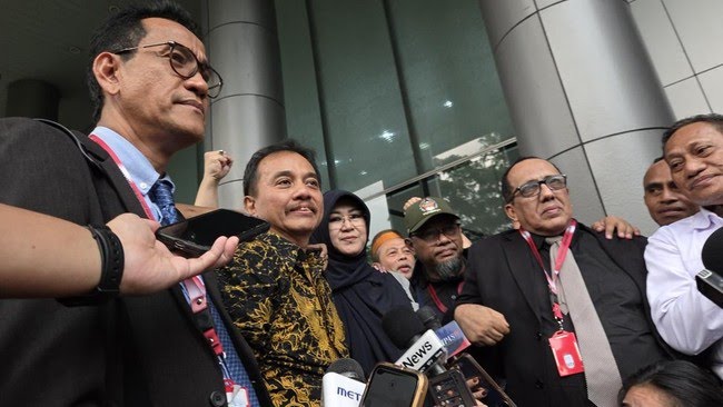 Dua orang pria dan wanita berjalan keluar dari gedung kejaksaan