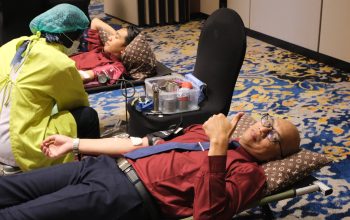 Peserta donor darah berbaring di kursi, petugas medis di sampingnya