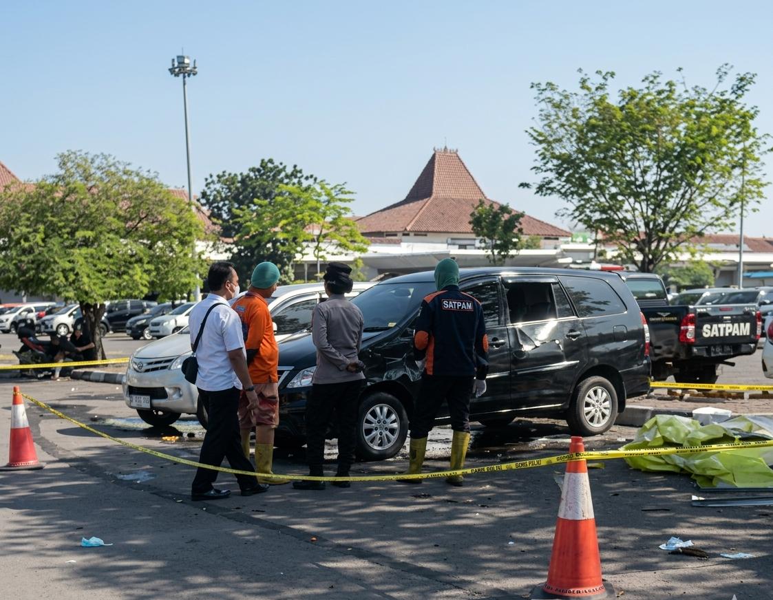 Petugas mengevakuasi jenazah dari mobil hitam di parkiran