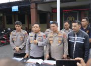 Polisi berbicara di depan mikrofon, latar spanduk Polresta Banjarmasin