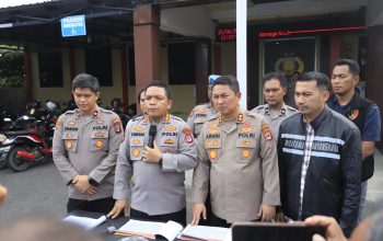 Polisi berbicara di depan mikrofon, latar spanduk Polresta Banjarmasin