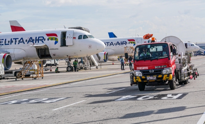Petugas mengisi Avtur ke pesawat di apron bandara.