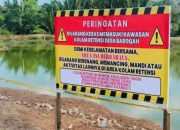 Plang peringatan di kolam retensi Desa Barokah
