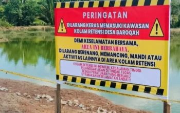 Plang peringatan di kolam retensi Desa Barokah