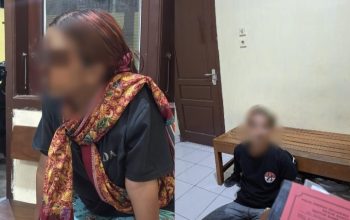 Dua tersangka duduk di ruang polisi, satu laki-laki satu perempuan