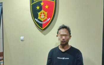 Pria duduk di kursi polisi, motor Scoopy hitam di belakangnya