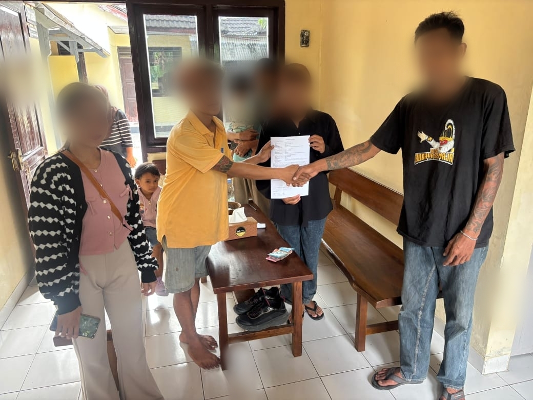 Dua pria bersalaman di ruang polisi, petugas dan wanita di samping mereka