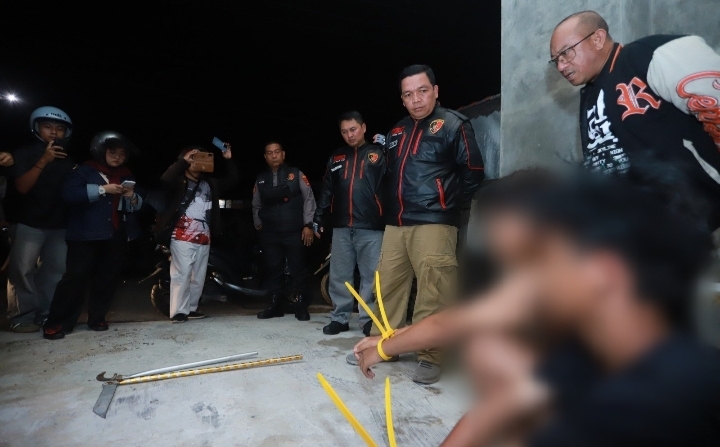 Polisi menggiring tiga remaja berjalan di halaman kantor polisi