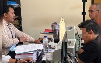 Polisi memeriksa pria duduk di kursi ruang pemeriksaan