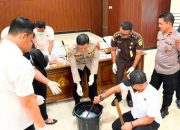 Beberapa pria berdiri di depan meja berisi plastik sabu