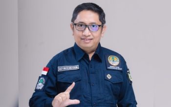 Pria berseragam dinas berbicara di depan papan informasi