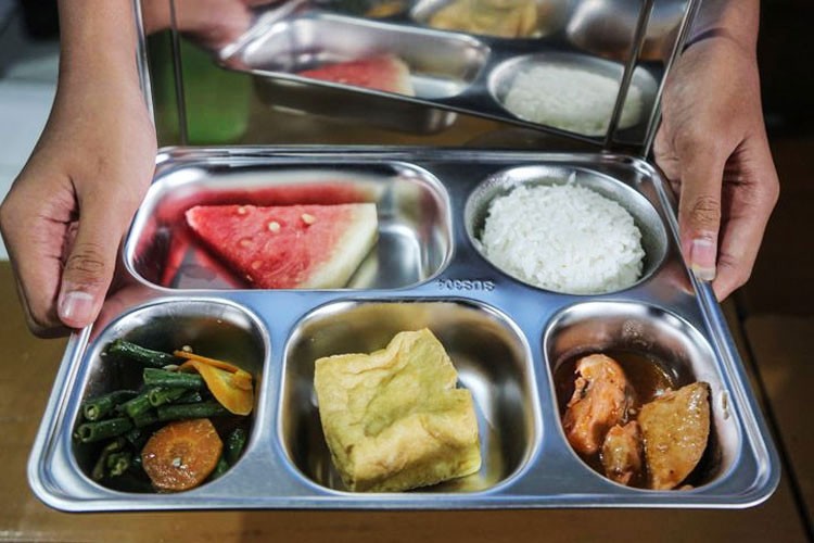 Hidangan nasi, lauk, sayur, dan buah dalam kotak makanan