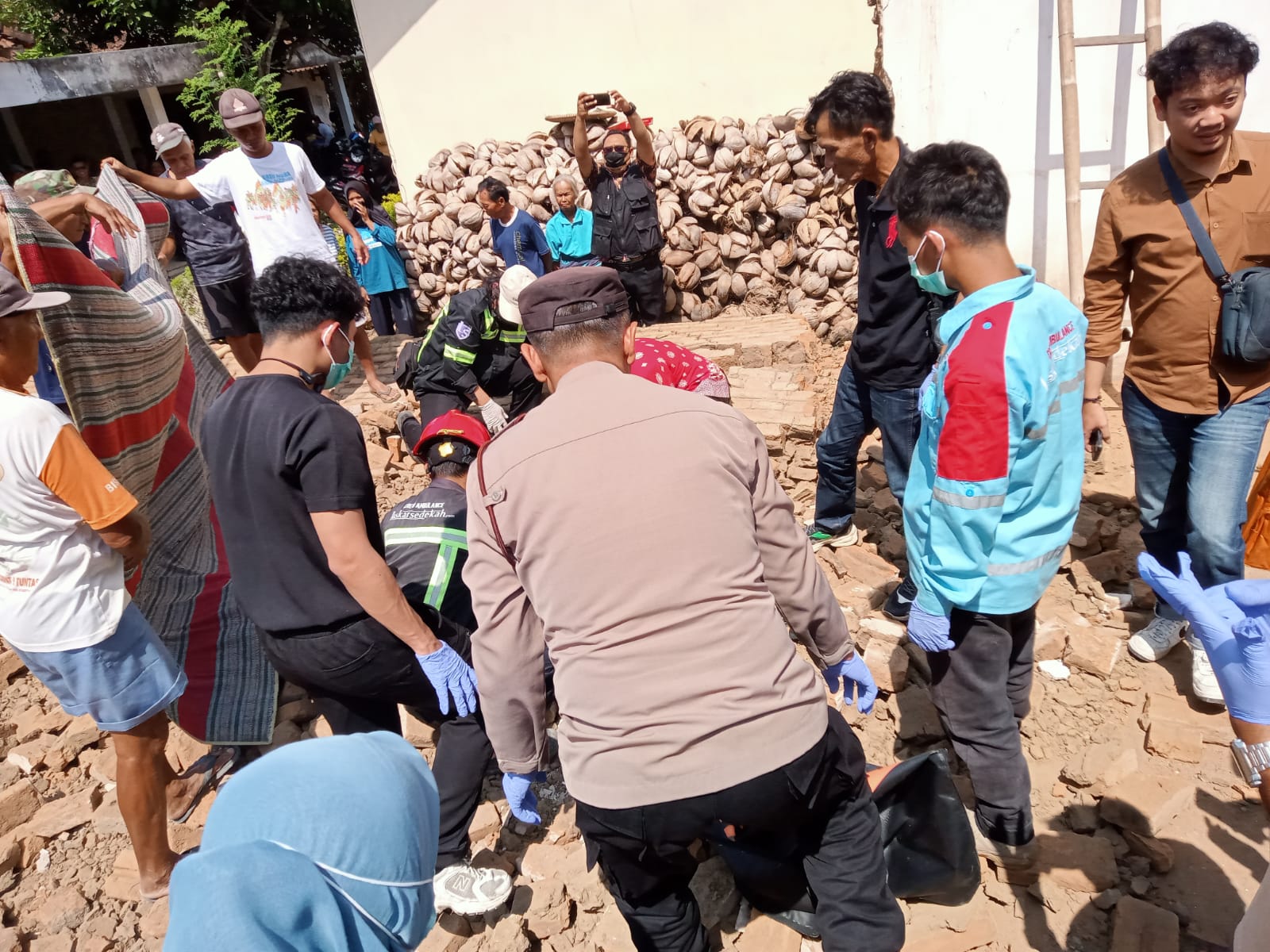 Petugas melakukan olah TKP dan evakuasi korban dalam peristiwa dinding rumah roboh saat pembongkaran bangunan di Godean, Kabupaten Sleman.