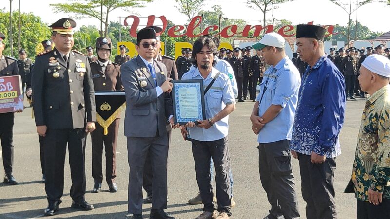 Bupati Tanah Bumbu dan Kapolres Tanah Bumbu menyerahkan piagam penghargaan kepada penyelam Jhonlin Grup pada peringatan Hari Bhayangkara ke-80.